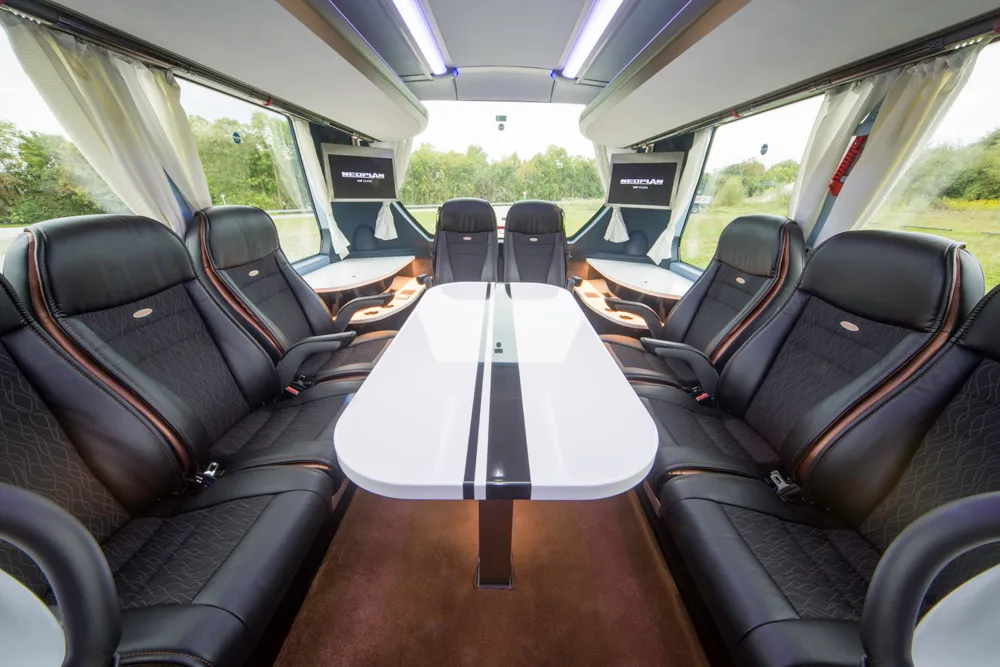 Clubtisch-Bereich mit Ledersesseln im VIP-Bus von Lagobus