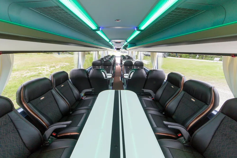 Innenraum eines VIP-Busses mit langem Clubtisch